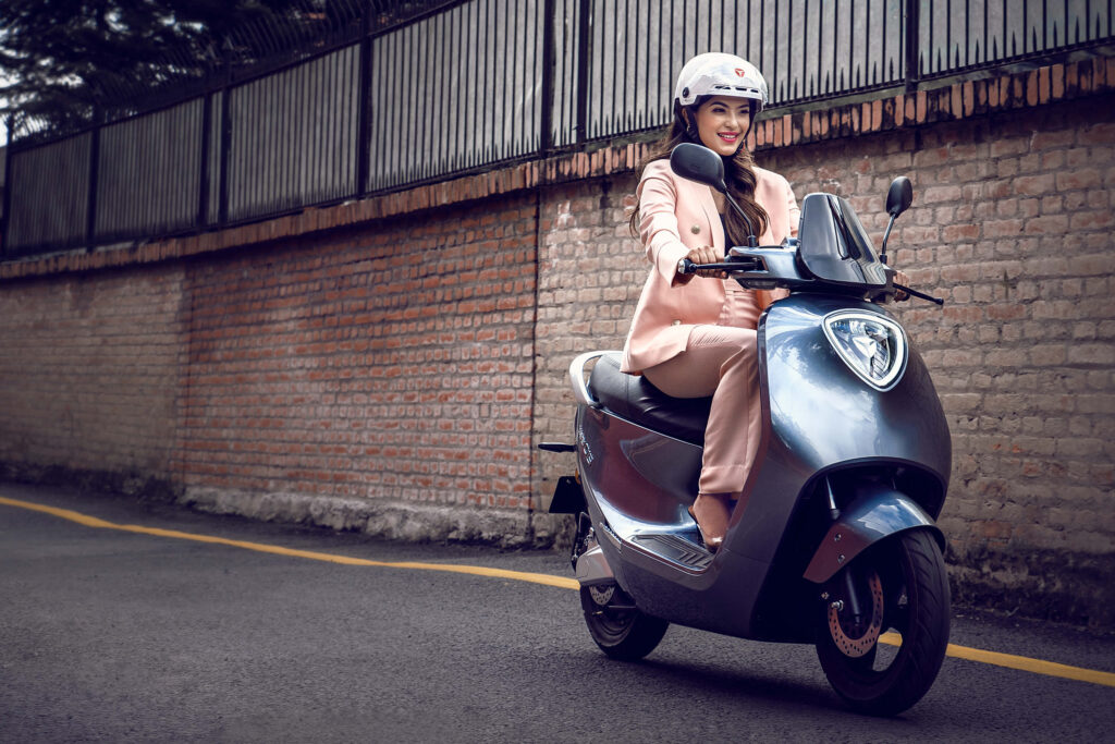 girl riding Yadea C1s electric scooter. everything you need to know about electric scooters